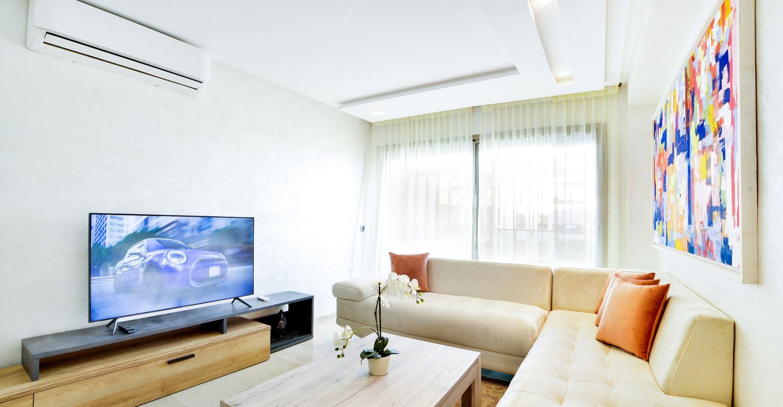 A bright apartment living room with a sofa by a large window